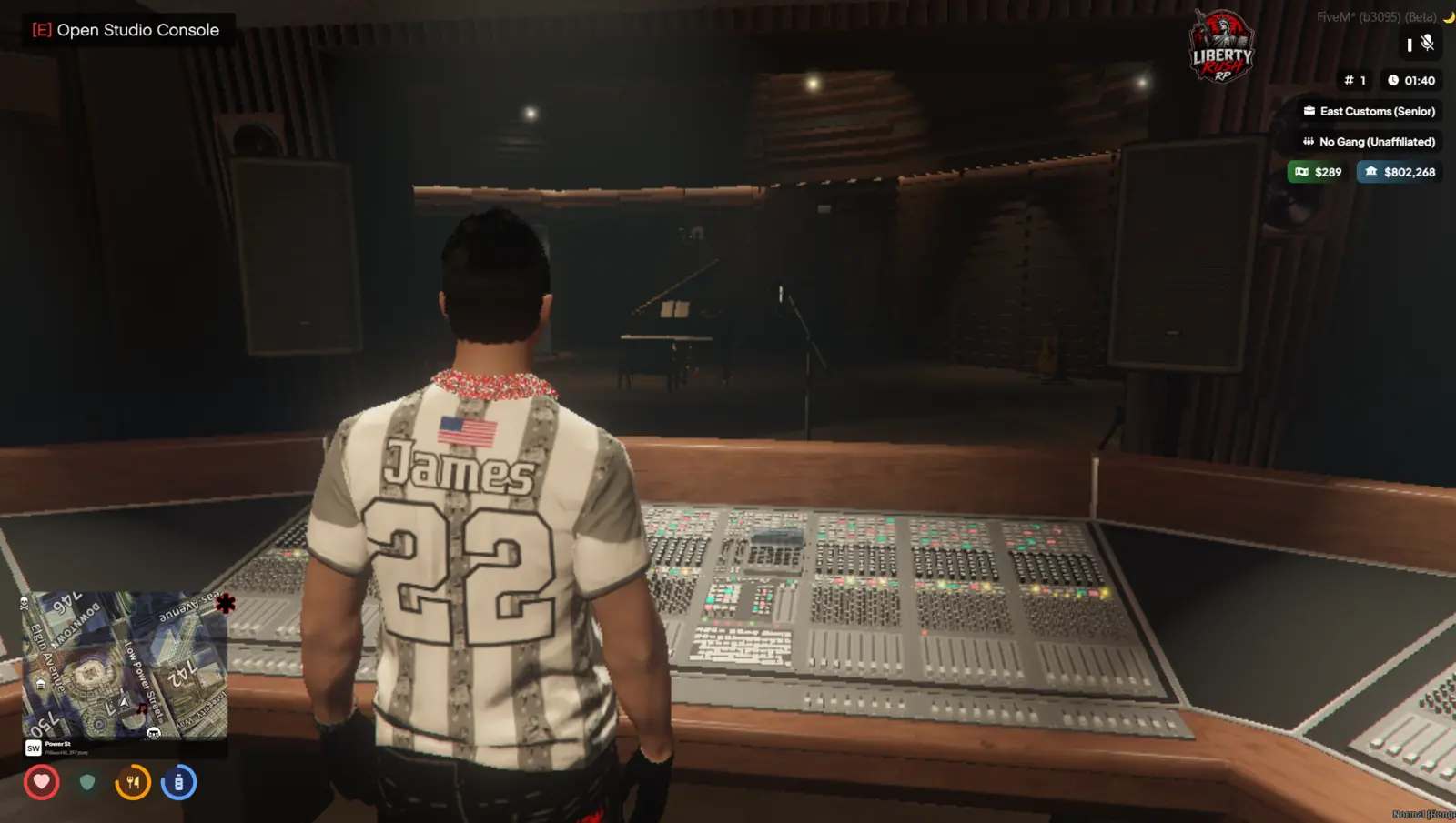 LibertyRush artist at the recording studio console overlooking the vocal booth